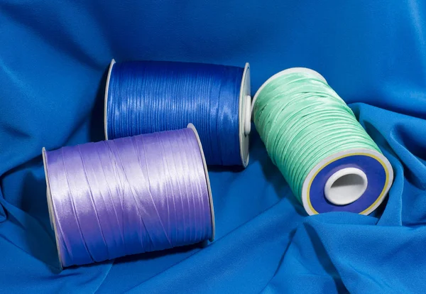 Carretéis de fio. Azul, verde, lavanda. em tecido — Fotografia de Stock