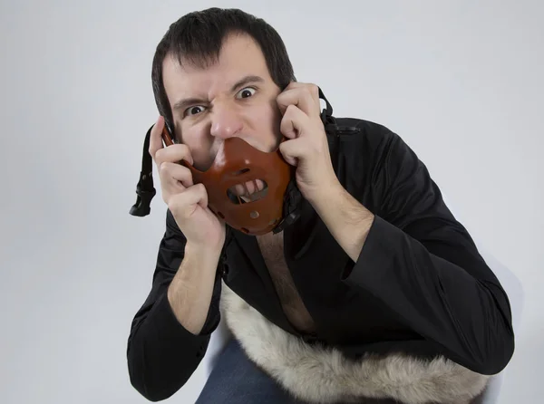 Young man with a mask on his face sits in a white chair — Stock Photo, Image