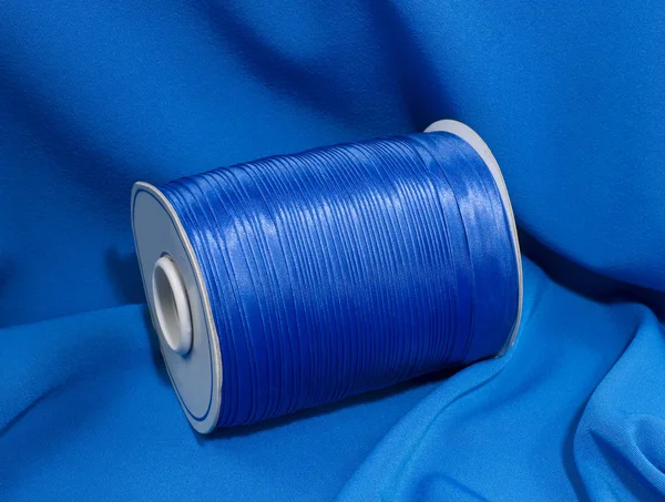 Шелковая голубая коса для шитья на голубой ткани . — стоковое фото