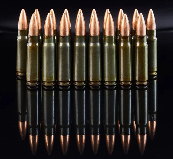 metal cartridges for hunting automatic weapons on a black background with a reflection