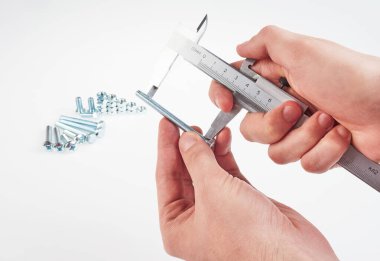 Kalibrelik cıvata ve fındıklı eller. beyaz arkaplan  