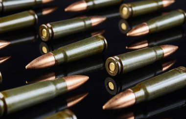 Siyah arka planda otomatik silah avlamak için kullanılan metal fişekler.    