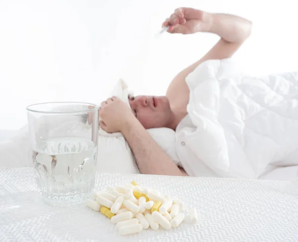 Unavený Nemocný Muž Gauči Pod Dekou Tabletami Teploměrem Bílém Pozadí — Stock fotografie