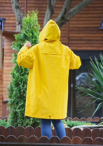 yellow rain cover from the back. Man in a yellow rain coat in the fall.