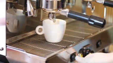 Barista el Başlat panel kahve makinesinde beyaz fincan kahve akar presler