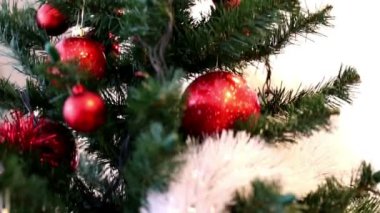 Kırmızı baubles, beyaz ve kırmızı garland, altın yıldız ve jingle bells ile süslenen Noel ağacı. Görünümden ilâ aşağı hareket.