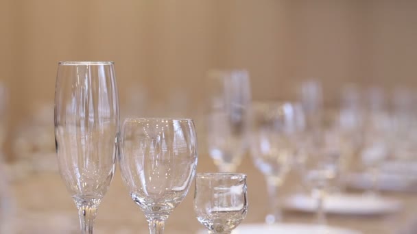 在餐厅的节日桌子上放着空杯的香槟酒 葡萄酒和伏特加 集中玻璃器皿的转移 餐桌装饰 — 图库视频影像