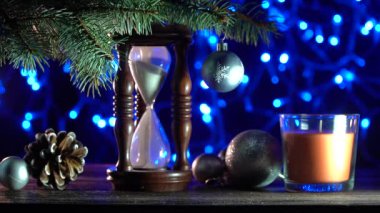 Noel arka plan, yeni yıla kadar ne kadar sürecek gösteren bir köknar ağacının altında bir kum saati. Xmas süslemeleri. Üstten görünüm. 4 k çözünürlükte filme