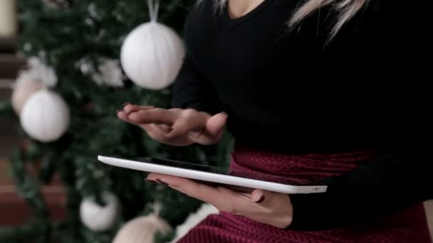 少女の手は タブレット上のテキストを選択します クリスマスの雰囲気は周りです 彼はショッピングやネット上の話 — ストック動画