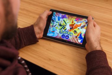 Prague, Çek Cumhuriyeti - 16 Mart 2019: Minecraft mobil oyun tutan bir smartphone ve kelepçelememz adam. Bir bambu zemin üzerine açıklayıcı bir editoryal görüntü.