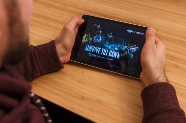 Prague, Çek Cumhuriyeti - 16 Mart 2019: Minecraft mobil oyun tutan bir smartphone ve kelepçelememz adam. Bir bambu zemin üzerine açıklayıcı bir editoryal görüntü.