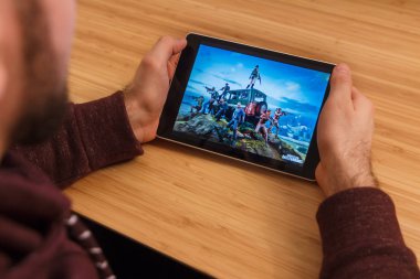 Prague, Çek Cumhuriyeti - 16 Mart 2019: bir akıllı telefon ve kelepçelememz Playerunknown s Battlegrounds Pubg mobil oyun tutan adam. Bir bambu zemin üzerine açıklayıcı bir editoryal görüntü.