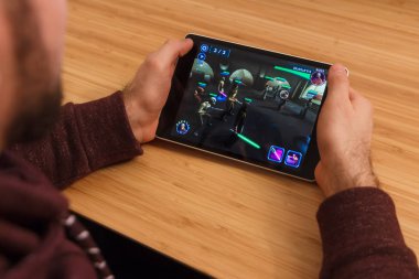 Prague, Çek Cumhuriyeti - 16 Mart 2019: bir akıllı telefon ve kelepçelememz Star Wars tutan adam: Heroes Galaxy mobil oyun. Bir bambu zemin üzerine açıklayıcı bir editoryal görüntü.