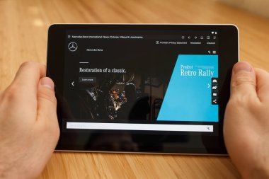 San Francisco, ABD-1 Nisan 2019: internet kullanarak ve Mercedes-Benz Web sitesi ile görünümlü tablet tutarak eller yakın, San Francisco, Kaliforniya, ABD. Açıklayıcı bir editoryal görüntü.