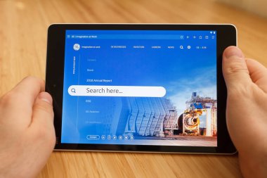 San Francisco, ABD-1 Nisan 2019: internet kullanarak ve GE Web sitesi aracılığıyla görünümlü tablet tutarak eller yakın, San Francisco, Kaliforniya, ABD. Açıklayıcı bir editoryal görüntü.