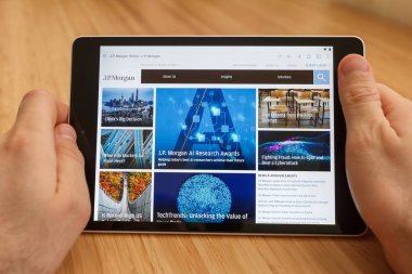 San Francisco, ABD-1 Nisan 2019: internet kullanarak tablet tutarak eller yakın ve J P Morgan Web sitesi aracılığıyla bakarak, San Francisco, Kaliforniya, ABD. Açıklayıcı bir editoryal görüntü.