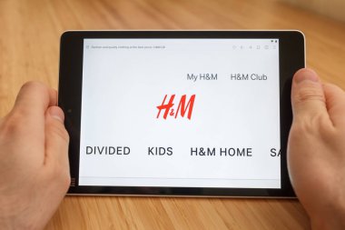 San Francisco, ABD-1 Nisan 2019: internet kullanarak ve HM Web sitesi aracılığıyla görünümlü tablet tutarak eller yakın, San Francisco, Kaliforniya, ABD. Açıklayıcı bir editoryal görüntü.