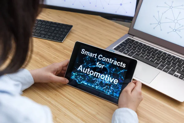 Business Female Using Smart Contracts For Automotive. Illustration of Ethereum Blockchain on the Screen of Tablet, PC and Laptop.