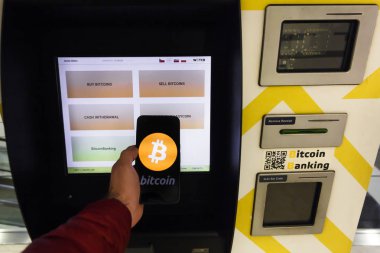 Prag, Çek Cumhuriyeti - 18 Mayıs 2019: Kripto para birimi alım ve satımı için Bitcoin Atm makinesi. Erkek akıllı telefon kullanarak Atm tarafından Bitcoins satıyor, Prag, Çek Cumhuriyeti. Açıklayıcı Bir Editoryal Resim.