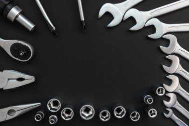 Siyah Arka Plan Üzerinde Farklı İnşaat Araçları ile Düz Lay Kompozisyon. Kontrol Listesi ve Çalışma Araçları, Anahtar, Tornavida, Plier Üst Görünümü.