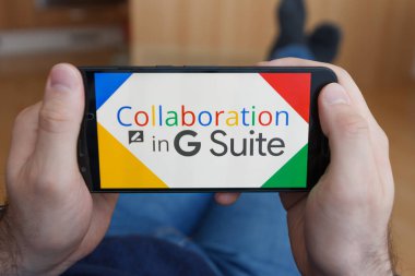 Los Angeles, Kaliforniya-3 Haziran 2019: G Suite uygulama işbirliğini kullanarak akıllı telefon tutan erkek ellere yakın. Açıklayıcı bir editoryal görüntü