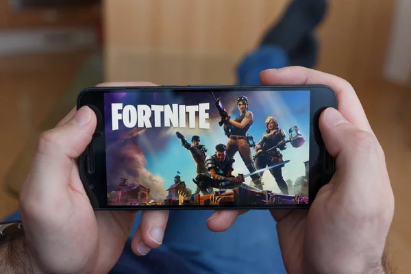 LOS ANGELES, CALIFORNIE - 3 JUIN 2019 : Lying Man tenant un smartphone et jouant au jeu Avengers : Endgame de Fortnite sur l'écran du smartphone. Une image éditoriale illustrative . — Photo