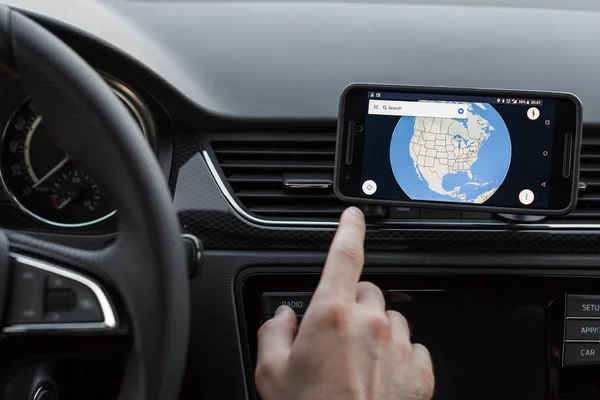 Feche até a condução masculina e usando a navegação na tela do smartphone. Escolha a direção, globo na tela . — Fotografia de Stock