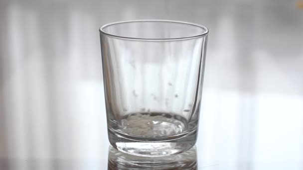 Basmati Rice is Pouring into a Transparent Empty Glass. Pouring a groats in a clear glass — Stock Video