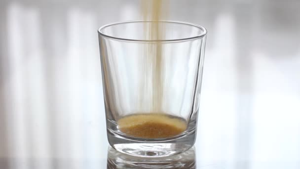 Cornmeal is Pouring into a Transparent Empty Glass. Pouring groats into a clear glass — Stock Video