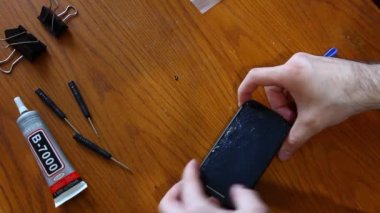 Onarım için kırık akıllı telefon bileşenleri sökme teknisyeni veya mühendis veya ahşap masada yeni akıllı telefon ekranı değiştirin