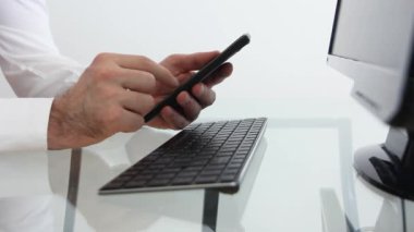 Los Angeles, Kaliforniya - 23 Haziran 2019: Akıllı telefon kullanan beyaz tıbbi ceketli doktor. Beyaz gömlekli işadamı akıllı telefon ekranında geziniyor.