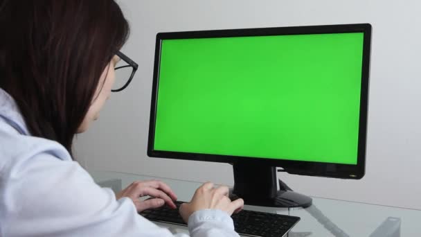 Los Angeles, Kalifornien-1 juni 2019: ingenjör, konstruktör, designer i glasögon arbetar på en persondator med en grön skärm på bildskärmen som har Chroma nyckel bra för mockup mall. Kamera — Stockvideo