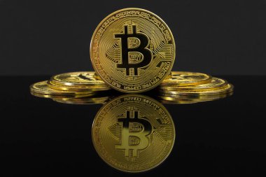 Büyük bir altın Btc sikke bir ayna yansıması. Bitcoin sikke siyah bir tablo ve siyah arka plan üzerindedir. Siyah arka planda izole altın bitcoin.