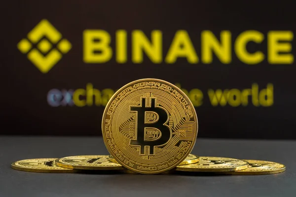 Binance kripto pazarının önünde merkezde büyük bir Bitcoin kripto para sikkesi ve diğer bitcoin paraları her iki taraftan. Mavi Binance kriptoborsa backgroun bitcoin sikke piramidi