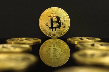 Büyük bir altın Btc sikke bir ayna yansıması. Bitcoin sikke siyah bir tablo ve siyah arka plan üzerinde.