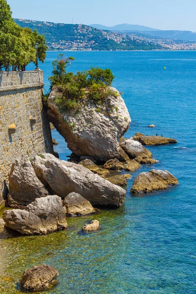 Taş duvara yakın deniz büyük kayalar vardır. Adriyatik Denizi 'nin mavi deniz suyunda büyük taşlar vardır, Tahkimatlar duvarına dokundu