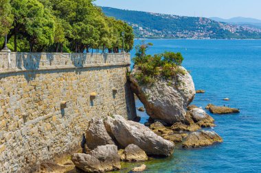 Taş duvara yakın deniz büyük kayalar vardır. Adriyatik Denizi 'nin mavi deniz suyunda büyük taşlar vardır, Tahkimatlar duvarına dokundu
