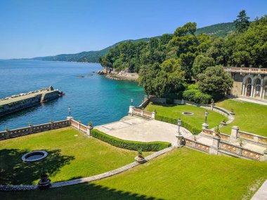 Adriyatik Denizi kıyısındaki Miramare 'nin bahçesinde bir üst görünüm. Yüksek ağaçlar ve yeşil çim ile güzel bir bahçe Miramare Caste, Triest, Italya topraklarında yer almaktadır.