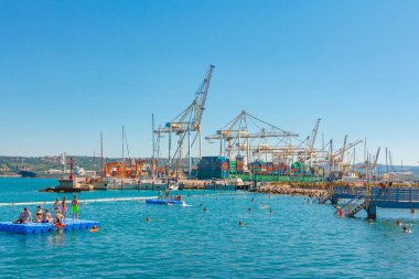 Liman Vinci ve lüks Cruise liner önünde sahilde yüzme insanlar. Koper, Slovenya