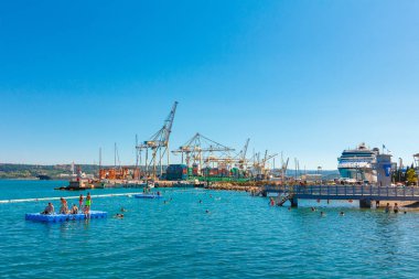 Liman Vinci ve lüks Cruise liner önünde sahilde yüzme insanlar. Koper, Slovenya