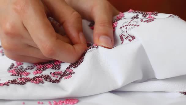 Close-up de agulha e linha, bordar padrões com grânulos. Vestido de noiva costura artesanal . — Vídeo de Stock