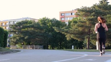 Erkekler ve kadınlar yerleşim alanı yakınındaki parkta paten