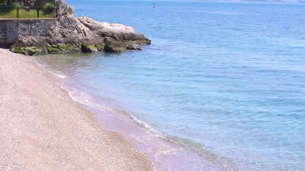 Vue imprenable sur la plage balnéaire avec de l'eau azur, du sable jaune et un petit rocher dans le coin de la photo. Un beau bord de mer de la mer Adriatique avec du sable jaune-blanc et de l'eau claire et transparente . — Video
