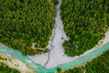 İsviçre'de ormanda akan Inn Nehri. Dağlarda mavi bir nehir üzerinde drone havadan görünümü