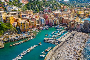 Camogli 'nin havadan görünüşü. Ligurian sahilinin yakınındaki renkli binalar. Yeşil mavi suyla marinada demirlemiş tekneler ve yatlarla yukarıdan manzara.