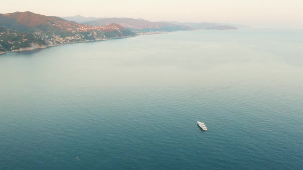 Filmato aereo delle montagne e del Mar Ligure con una barca bianca al tramonto. Santa Margherita Ligure, vicino Portofino, Italia — Video Stock