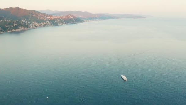 Flygbilder av bergen och Liguriska havet med en vit båt vid solnedgången. Santa Margherita Ligure, nära Portofino, Italien — Stockvideo