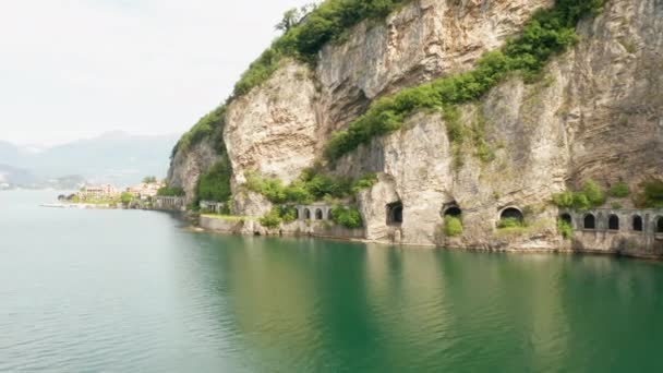 イタリアのレッコ湖の隣に緑の木がある花崗岩の山のグルモトンネルに沿って空中撮影 — ストック動画