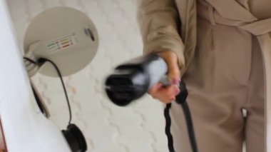 Kamu şarj istasyonundaki elektrikli bir EV 'nin kadın şarj işleminin başlatılması, Haziran 2020, Prag, Çek Cumhuriyeti.