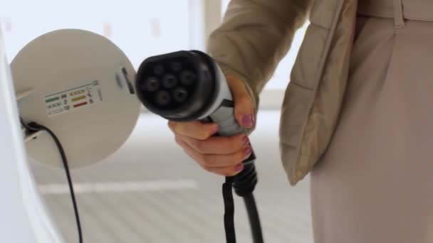 Femme branchant un câble d'alimentation à la voiture électrique. Véhicule zéro émission, juin 2020, Prague, République tchèque. — Video